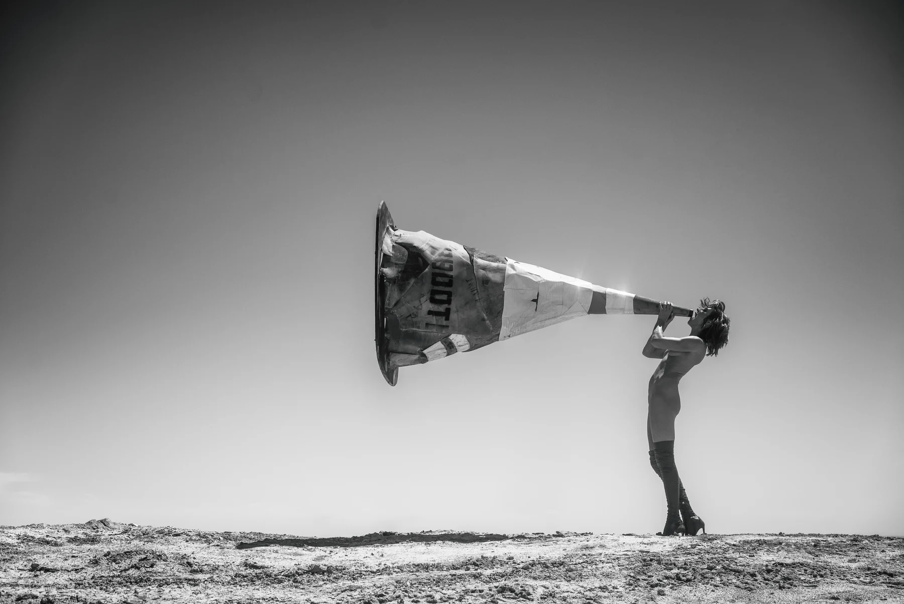 Cone Of Silence — A traffic cone becomes an oversized mouthpiece facing the horizon. Photograph by Albert Pocej, California.