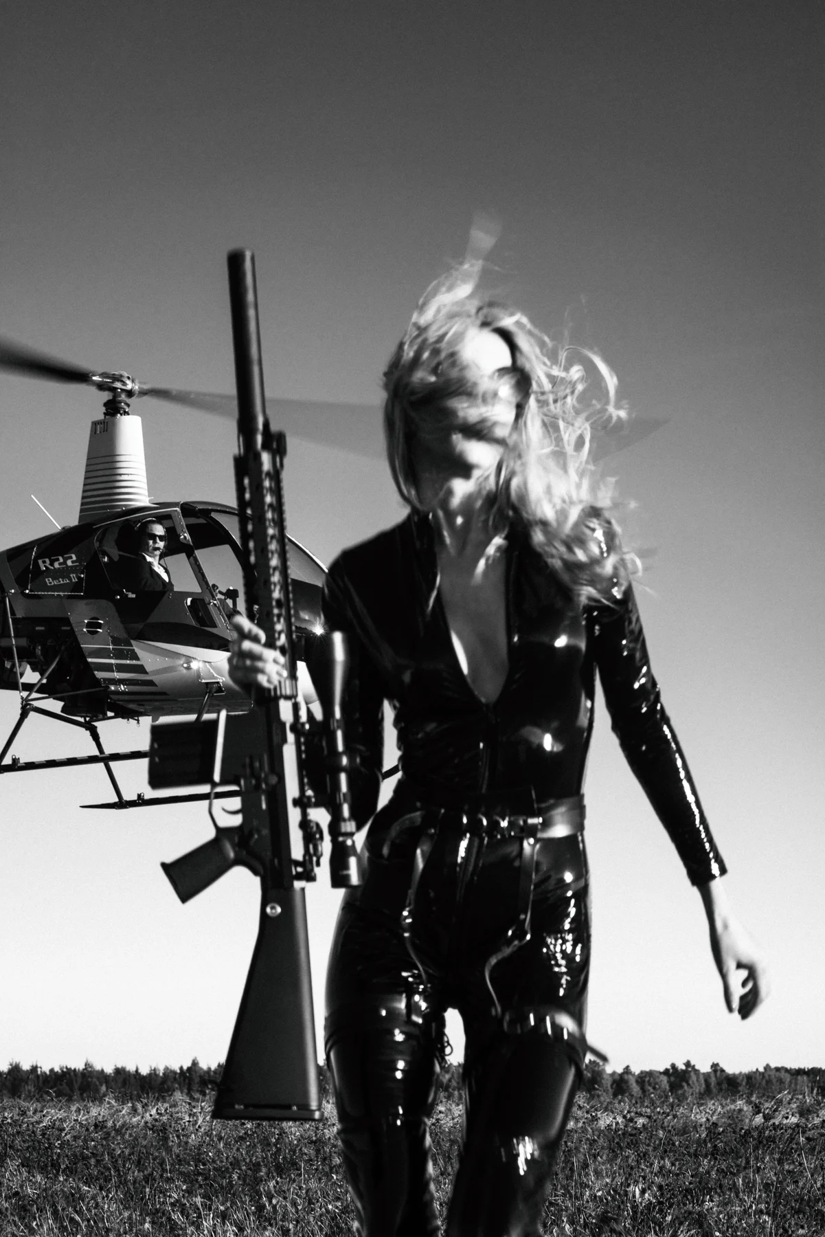 Day At The Office — A rifle, a helicopter and a woman dressed for an extraordinary working day. Photograph by Albert Pocej, On the Edge.