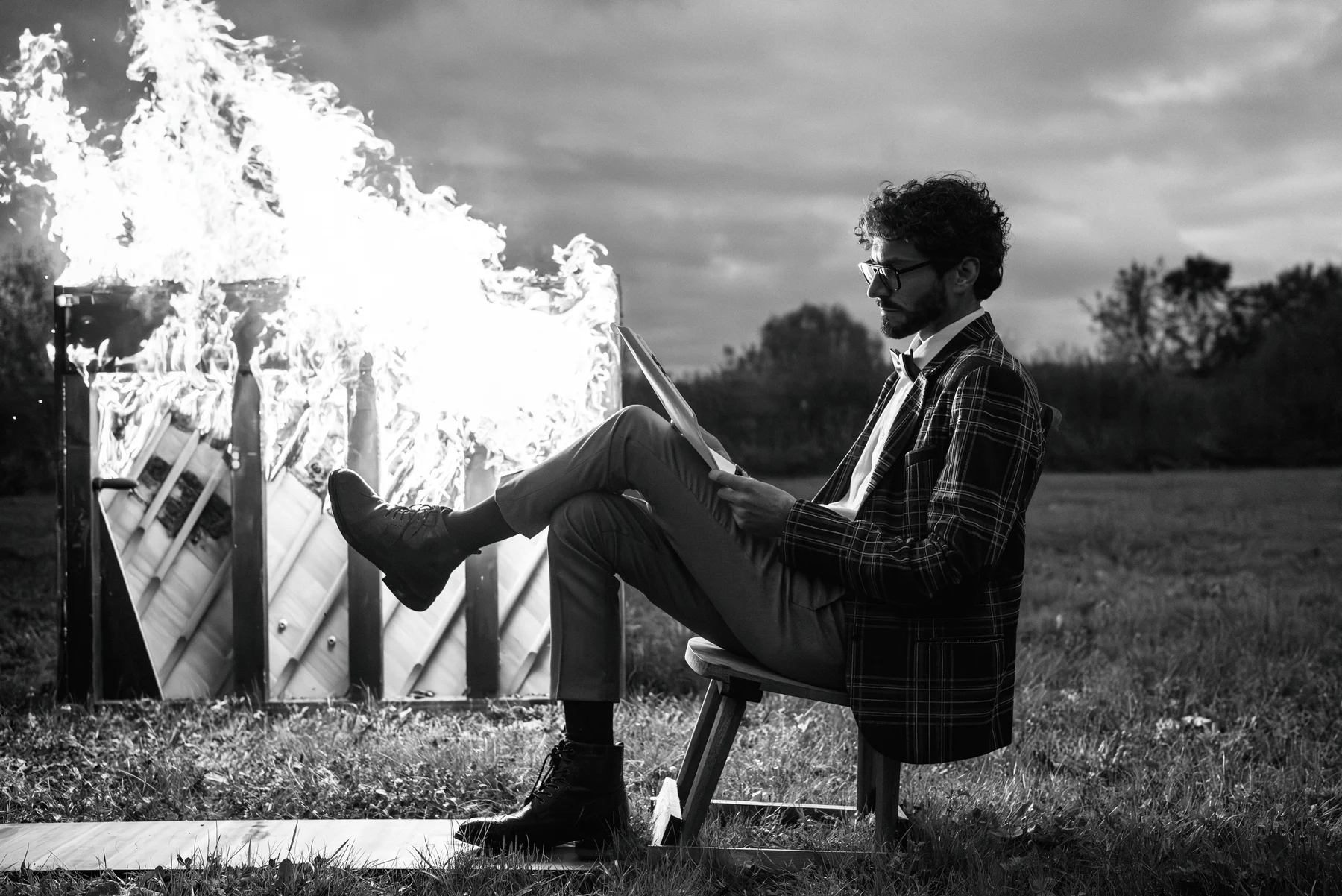 Fahrenheit 440 — A seated figure rests a foot against a burning piano. Photograph by Albert Pocej, Perfectly Normal.