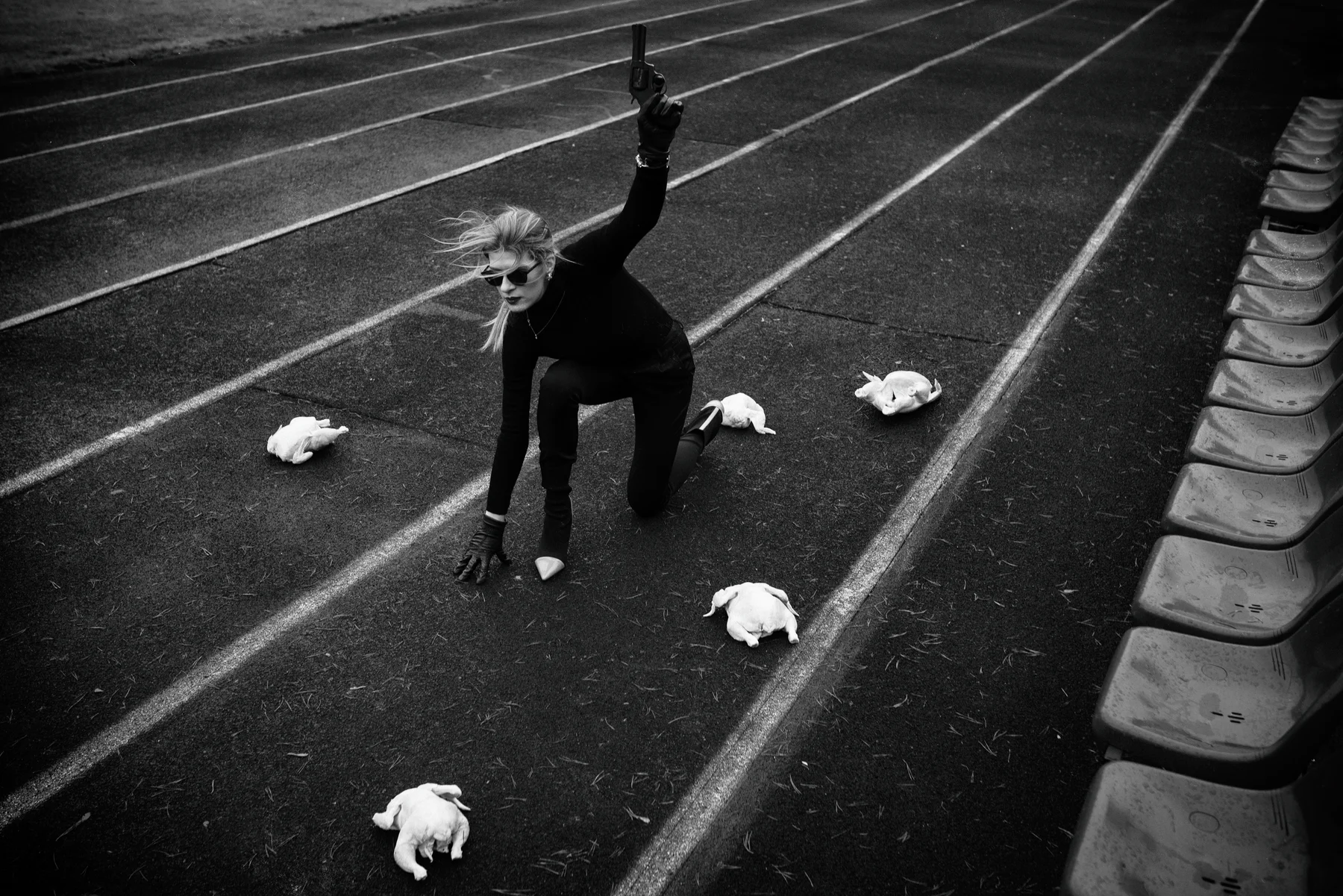 Fowl Play — A starting pose, a raised pistol and chickens on a running track. Photograph by Albert Pocej, Attachment Issues.