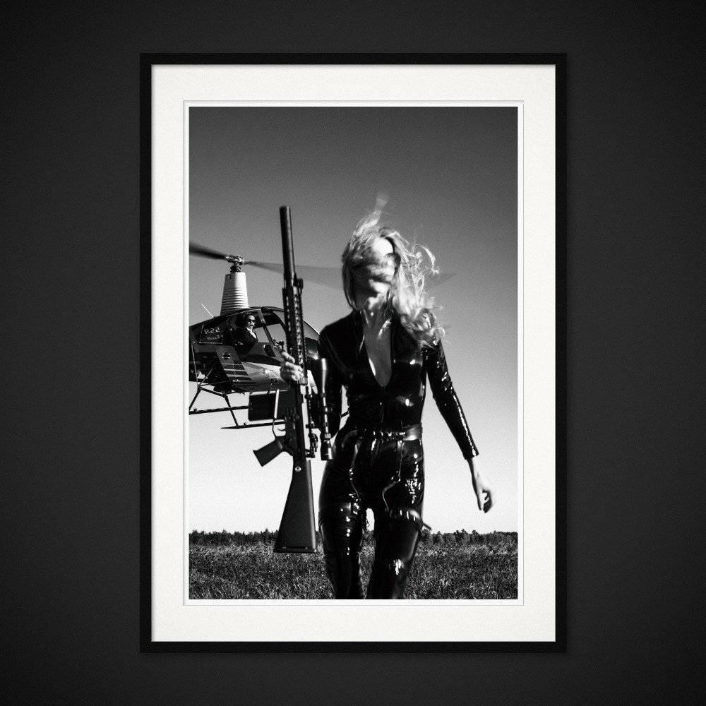 Day At The Office — A rifle, a helicopter and a woman dressed for an extraordinary working day. Framed edition by Albert Pocej.