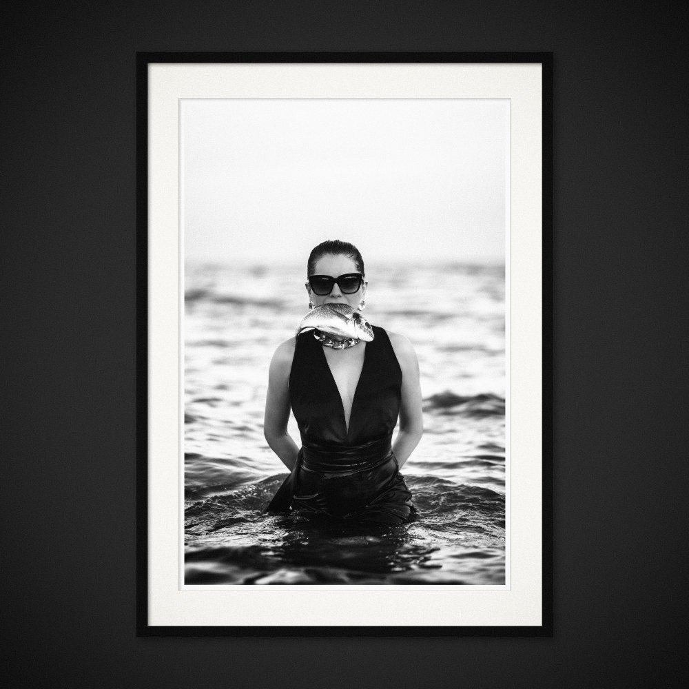 Silk And Salt — A fish held across the mouth; an evening dress in the water. Framed edition by Albert Pocej.